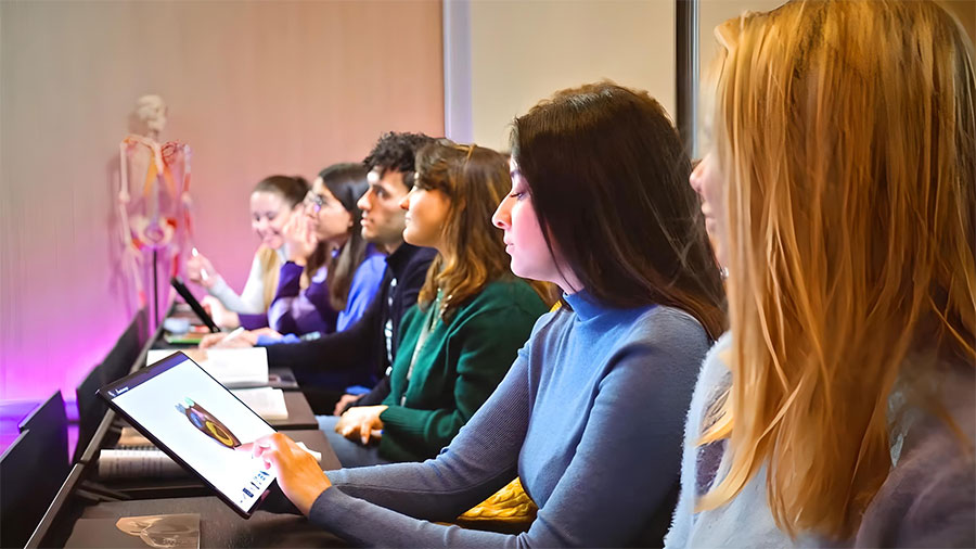 University students engaging with digital anatomy material on Anatomage Tablets in a classroom setting, enhancing anatomy education through interactive 3D visualization.