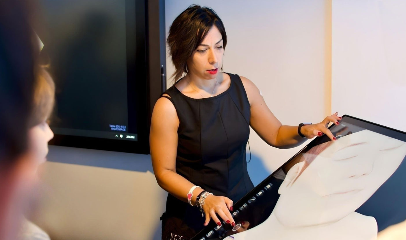 Clinical professional using Anatomage’s 3D DICOM viewer to display medical imaging and improve patient communication.
