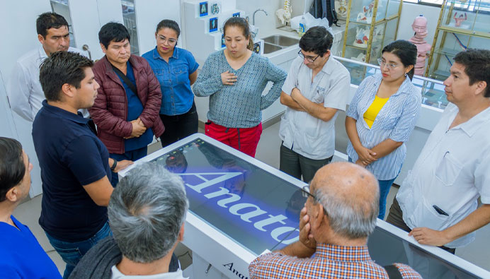 Medical professionals using the Anatomage Table’s 3D models to explain pathological anatomy to patients, enhancing clinical communication and medical education.