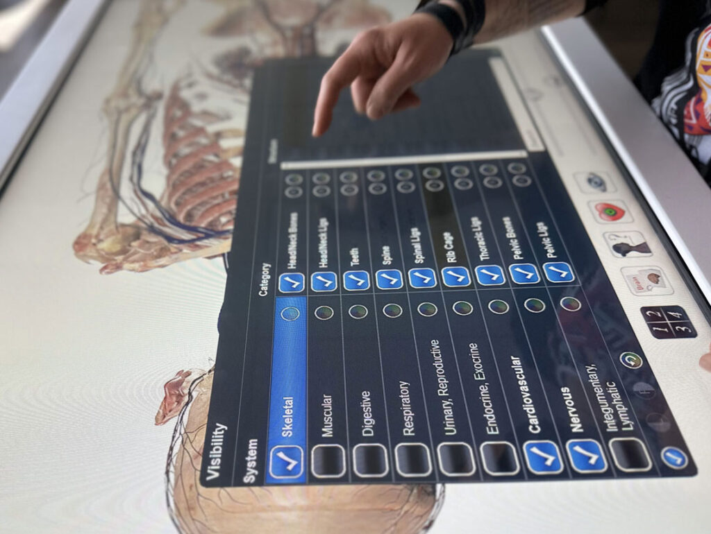 Medical workers using the Anatomage Table to perform surgical simulations for clinical training and anatomy education.