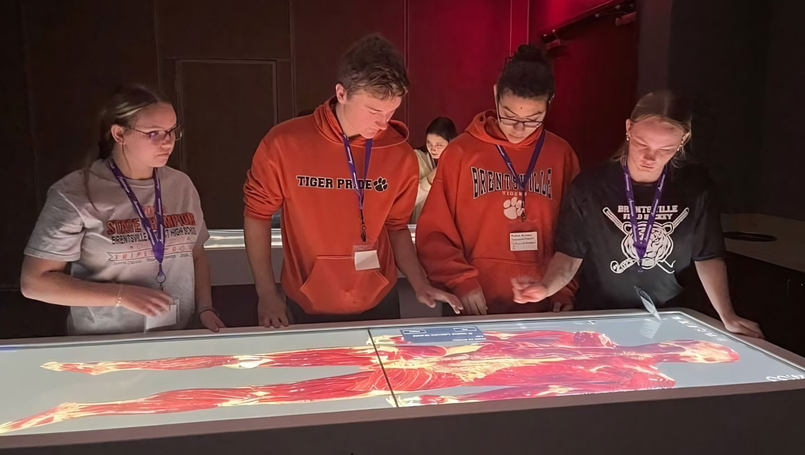 Brentsville High School students using the Anatomage Table to explore 3D virtual cadavers for interactive anatomy education.