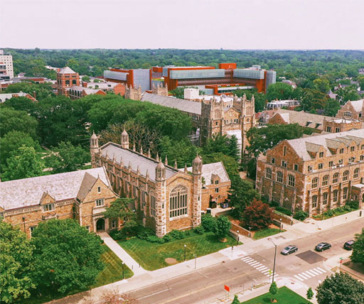 Aerial view of University of Michigan campus featuring historic Gothic-style academic buildings surrounded by trees, showcasing the university’s extensive educational facilities and STEM learning environment.