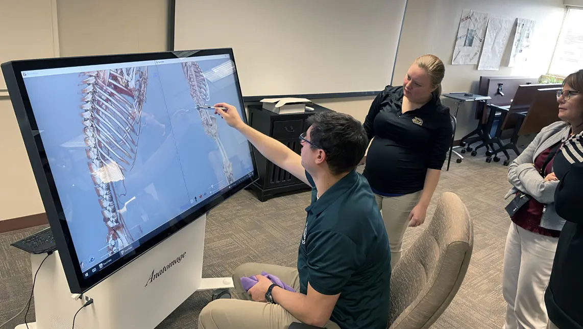 Medical school instructors using the Anatomage Table to show detailed radiology images of skeletal structures for anatomy education and clinical training.