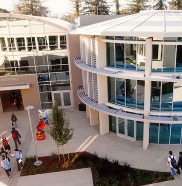 Students walking outside Nichols Hall at The Harker School campus, featuring modern glass architecture, used for high school education and STEM learning.