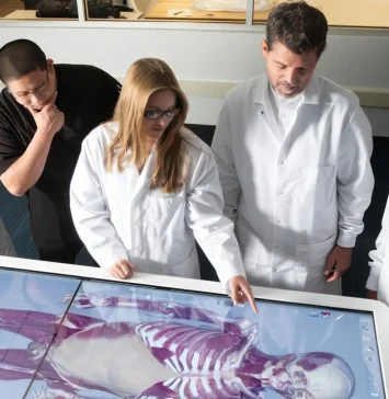 University faculty and students interacting with the Anatomage Table.