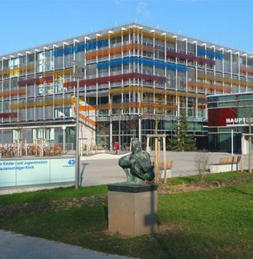 Front view of University of Heidelberg Medical School building with colorful glass facade and entrance sign, featuring modern architecture for medical education in Germany.